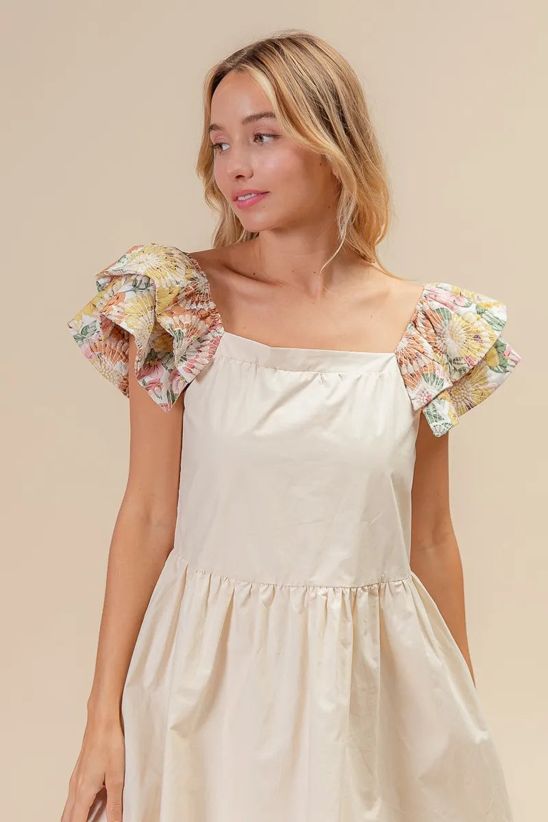 Model wearing The Everly Embroidered Bloom Dress with floral print sleeves and delicate flower embroidery, styled for spring.