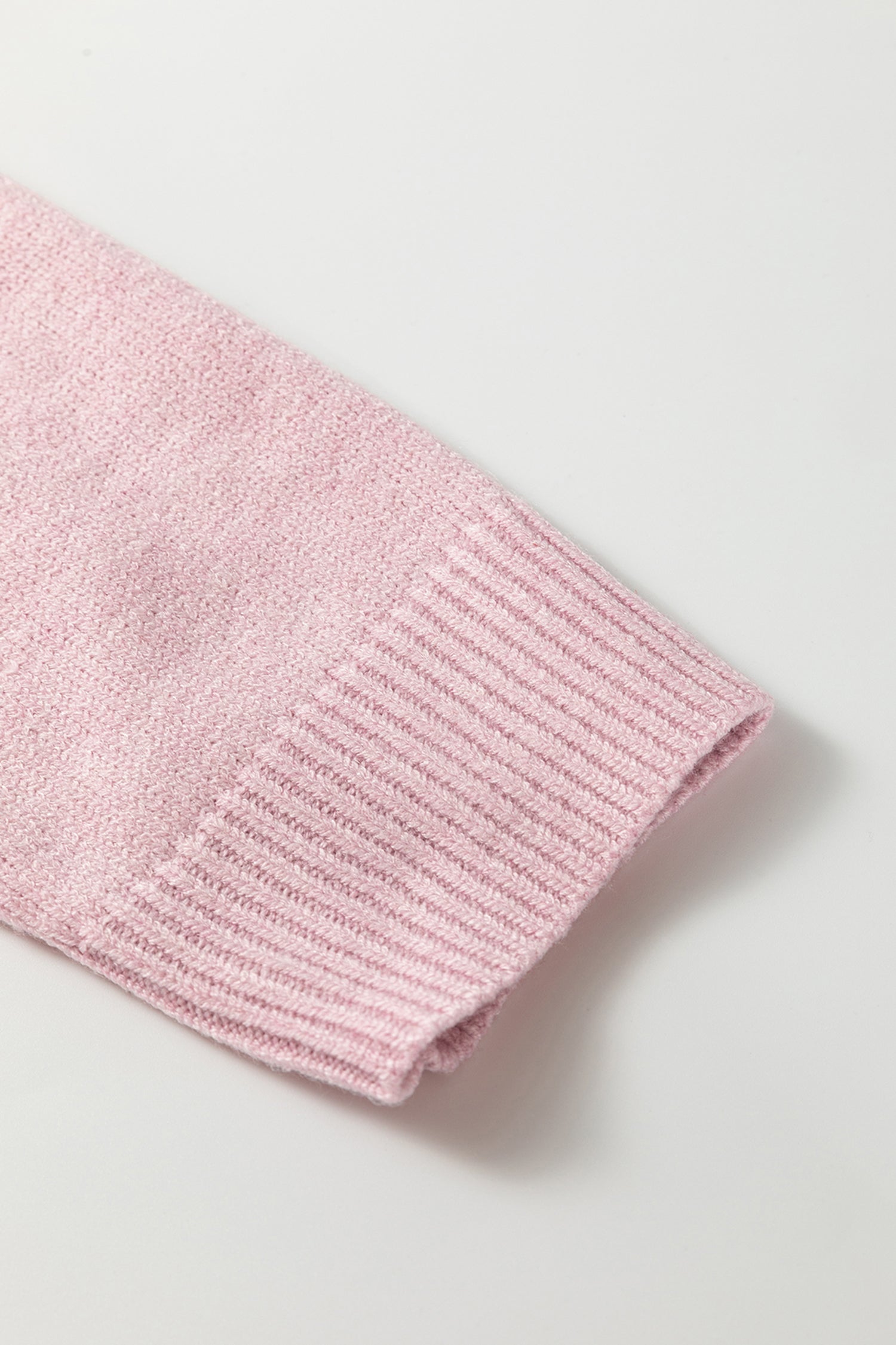 Close-up of a pink knitted garment on a light gray background