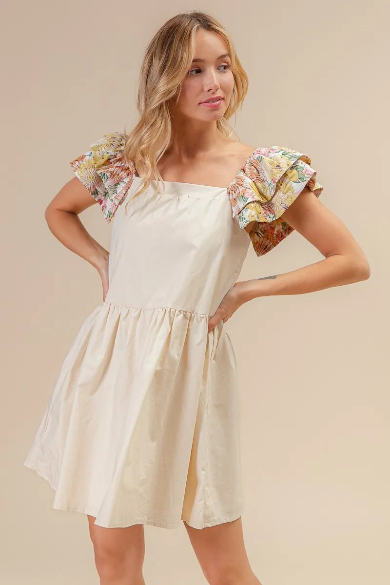 Model wearing The Everly Embroidered Bloom Dress with floral print sleeves and delicate flower embroidery, styled for spring.