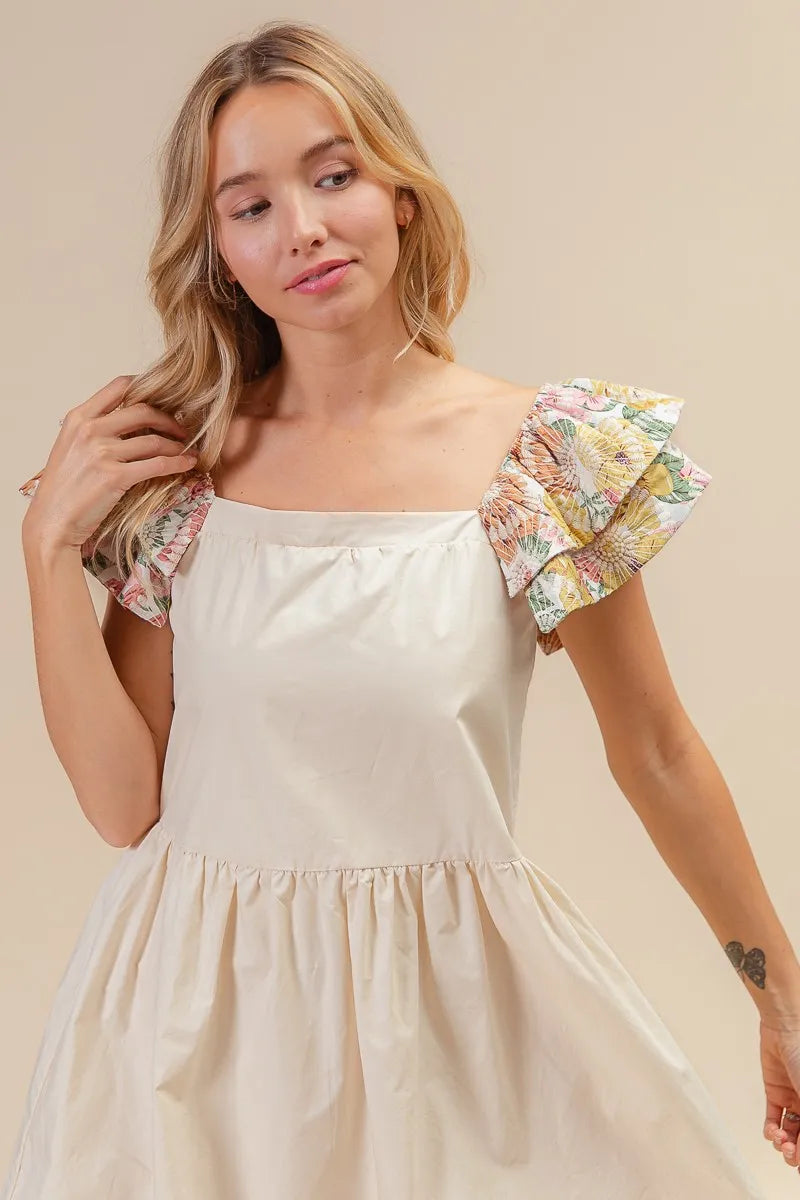 Model wearing The Everly Embroidered Bloom Dress with floral print sleeves and delicate flower embroidery, styled for spring.