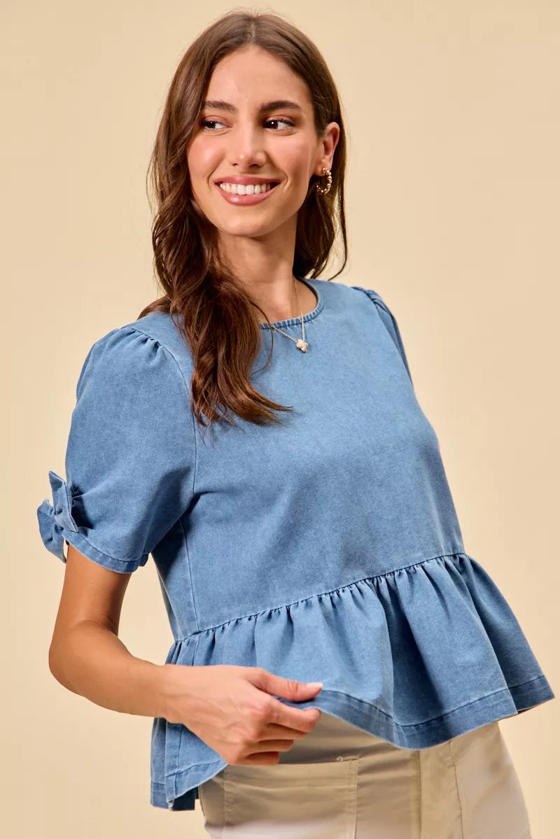 Blue denim bow top with peplum hem styled for everyday wear at Thread Bar Boutique front view