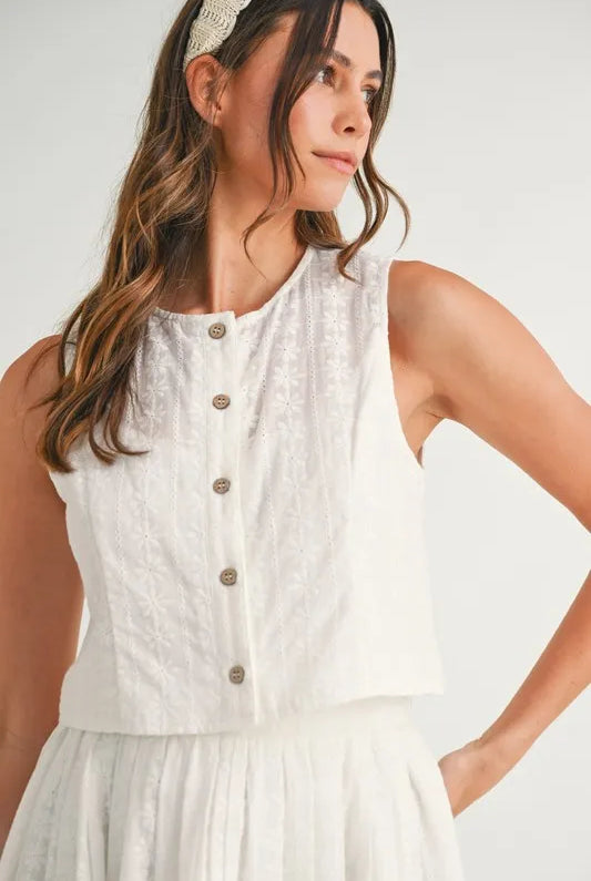 Two-piece set featuring an eyelet lace top and mini skirt, styled for a trendy and feminine look