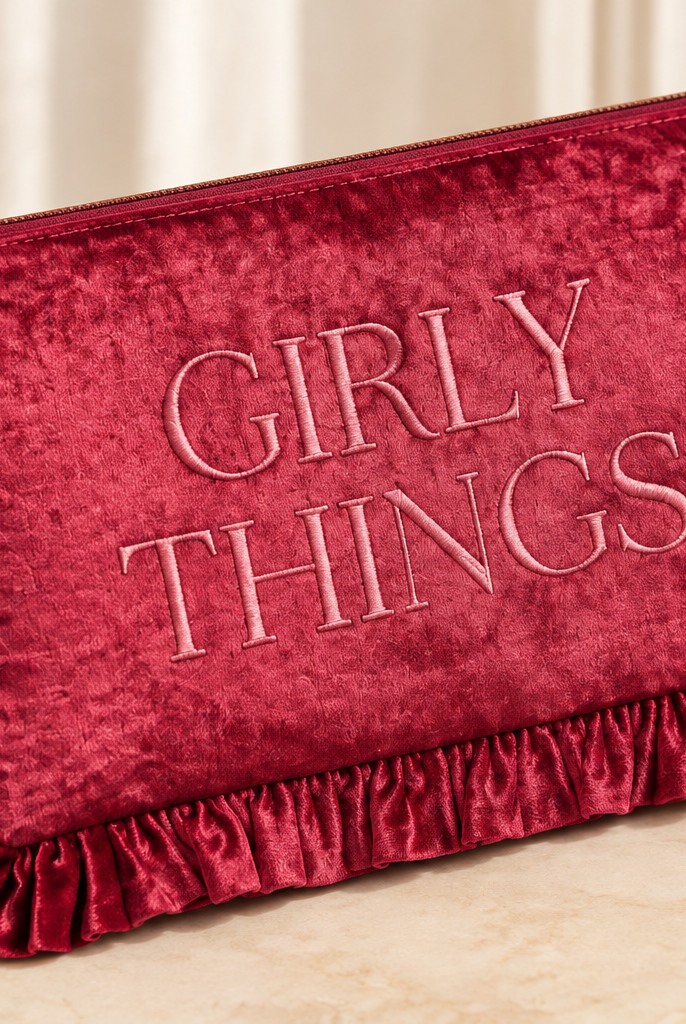 Thread Bar Boutique soft pink velvet cosmetic pouch featuring embroidered “The Essentials” or “Girly Things” lettering, ruffle trim, and zip closure for makeup and beauty essentials
