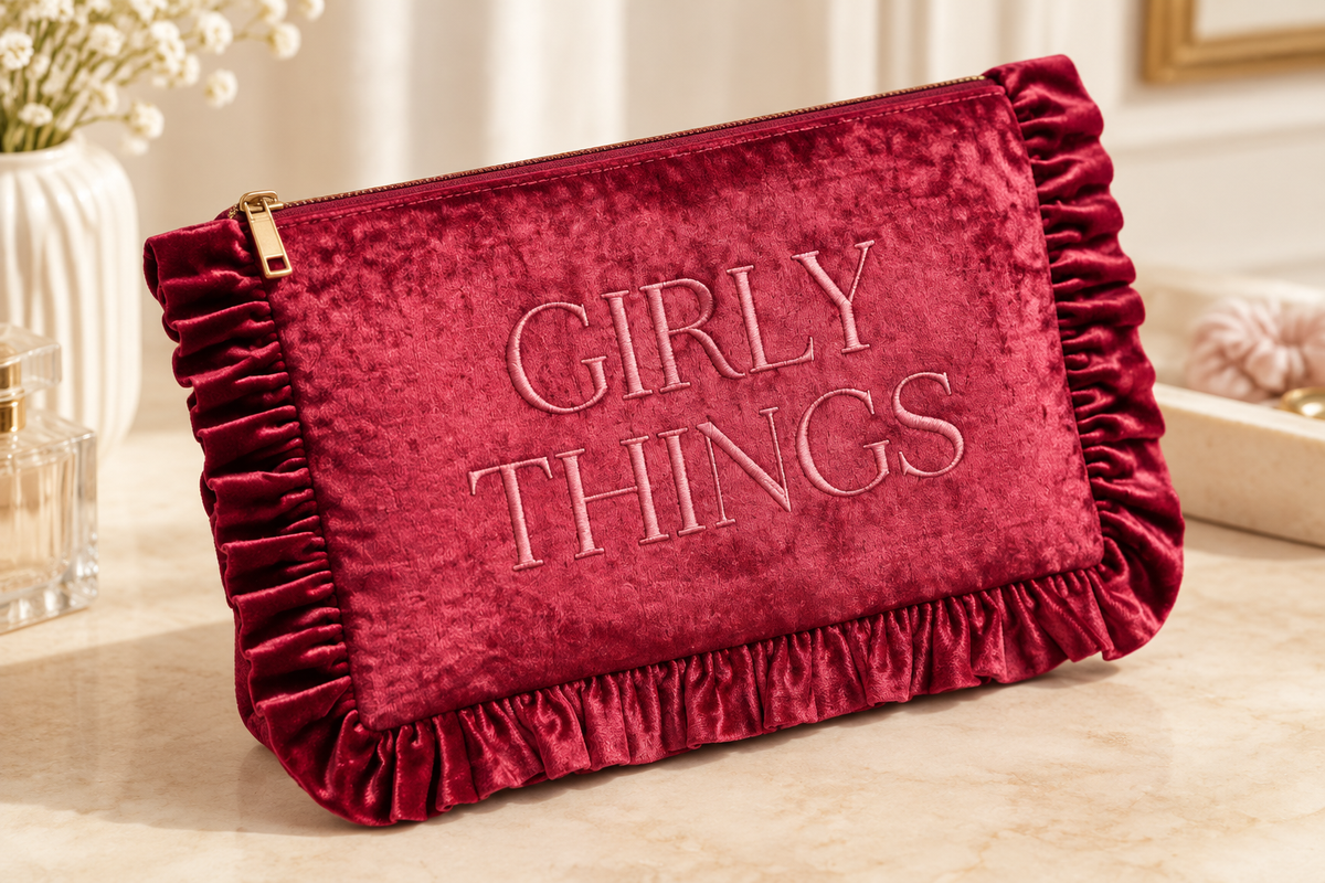 Thread Bar Boutique soft pink velvet cosmetic pouch featuring embroidered “The Essentials” or “Girly Things” lettering, ruffle trim, and zip closure for makeup and beauty essentials