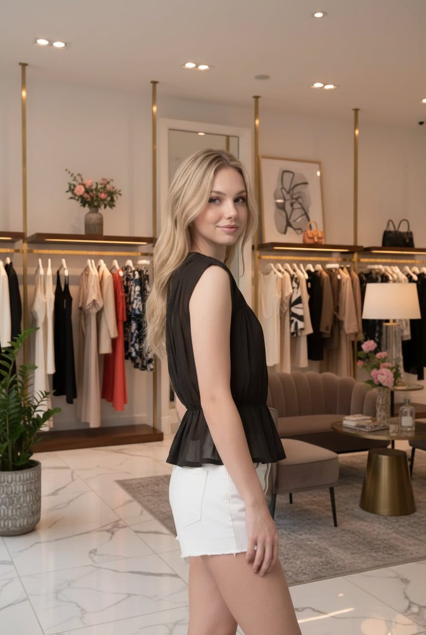 Feminine women's peplum top with shirred bodice, breezy knit material, round neckline, and flared hem for a flattering fit.