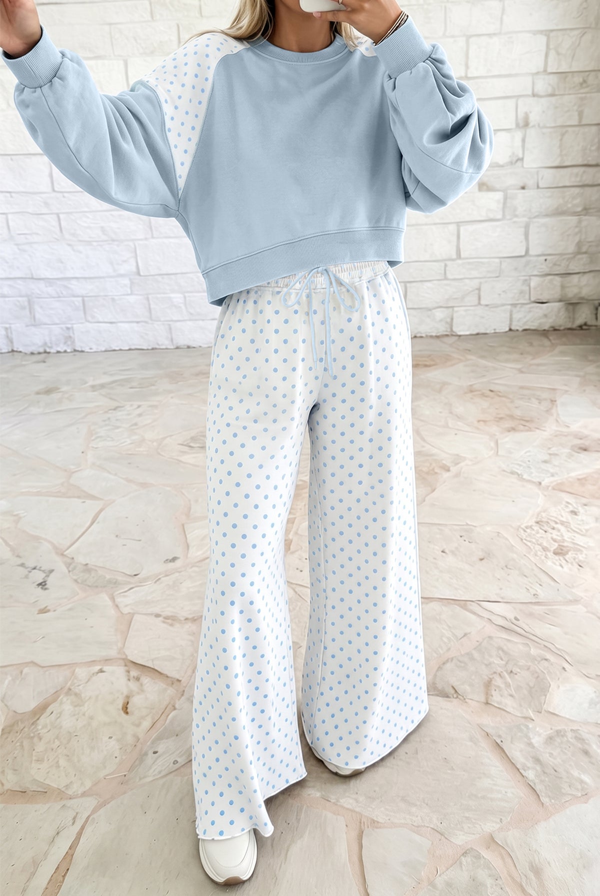 Women’s light blue lounge set featuring a cropped sweatshirt and matching wide-leg drawstring pants, combining a relaxed silhouette with a playful colorblock polka dot design.