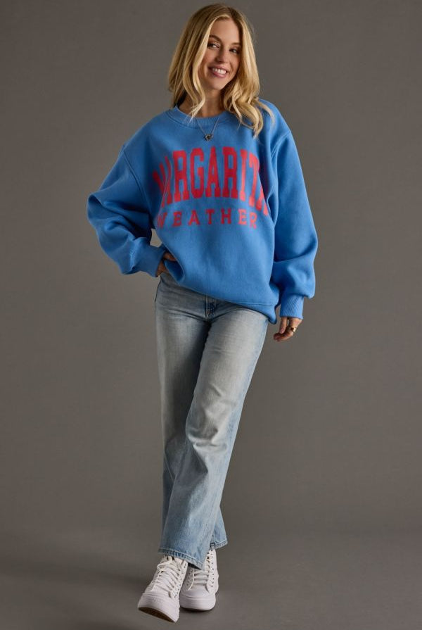 Woman wearing a vintage blue margarita weather graphic sweatshirt