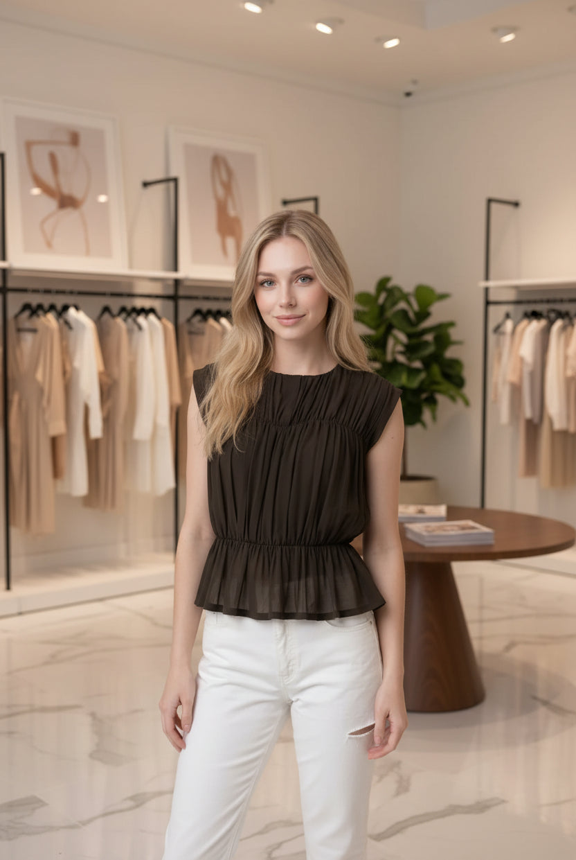 Women's semi-sheer peplum blouse with textured shirring, fitted silhouette, cap sleeves, and soft lightweight knit fabric.