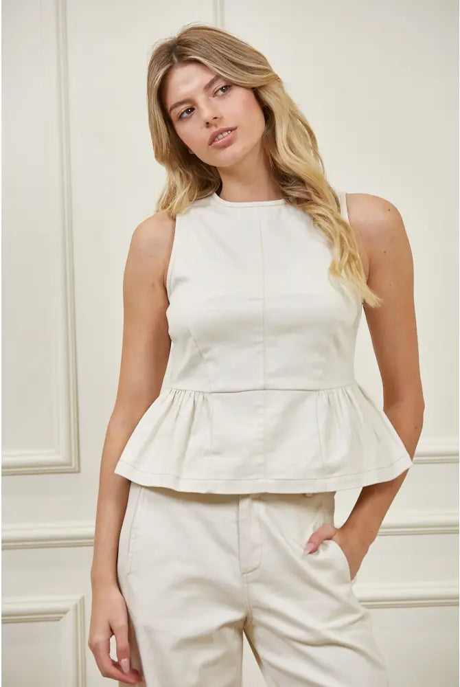 Sleeveless high neck peplum top with fitted bodice, structured woven fabric, vertical seaming, and flared peplum hem