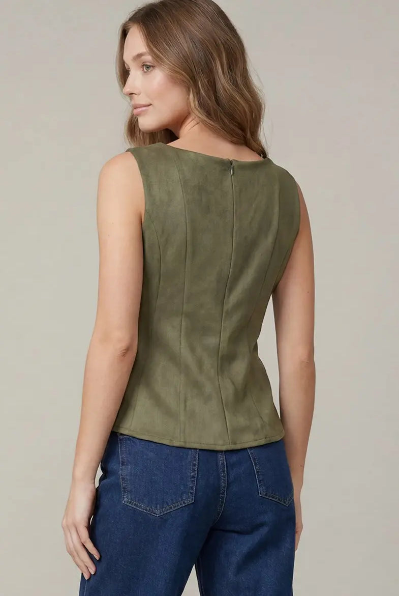 Women's sleeveless suede peplum blouse styled with tailored trousers for a polished office and business casual outfit
