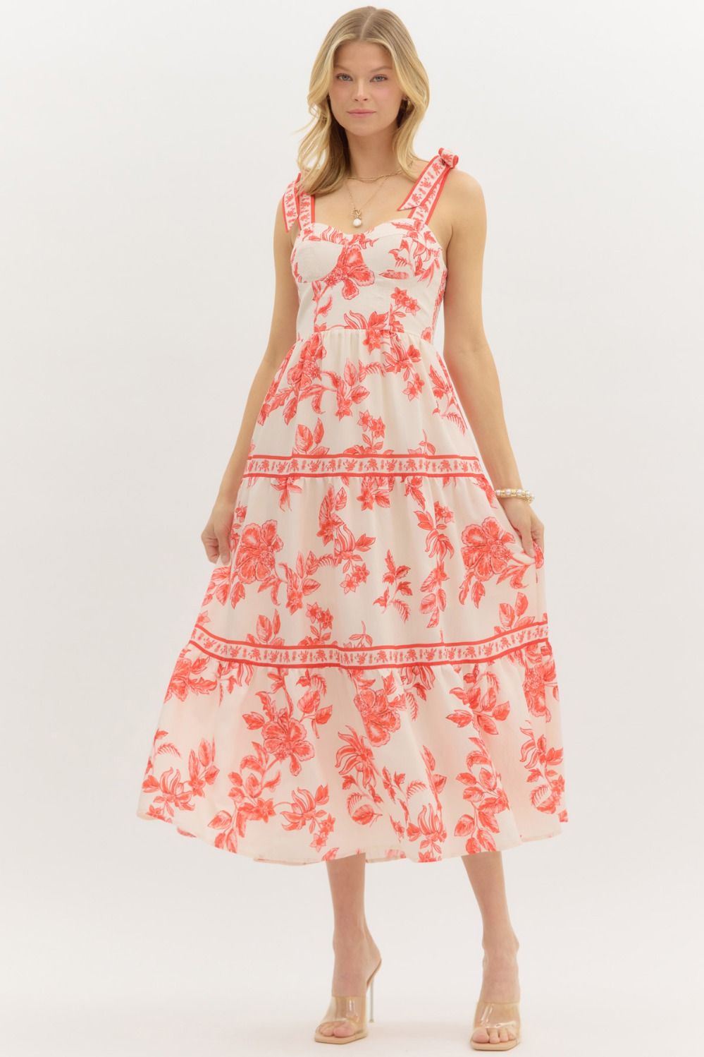Model wearing a cream and burnt orange floral tiered maxi dress with tie straps, lined with hidden side pockets – Sunset Soirée Maxi