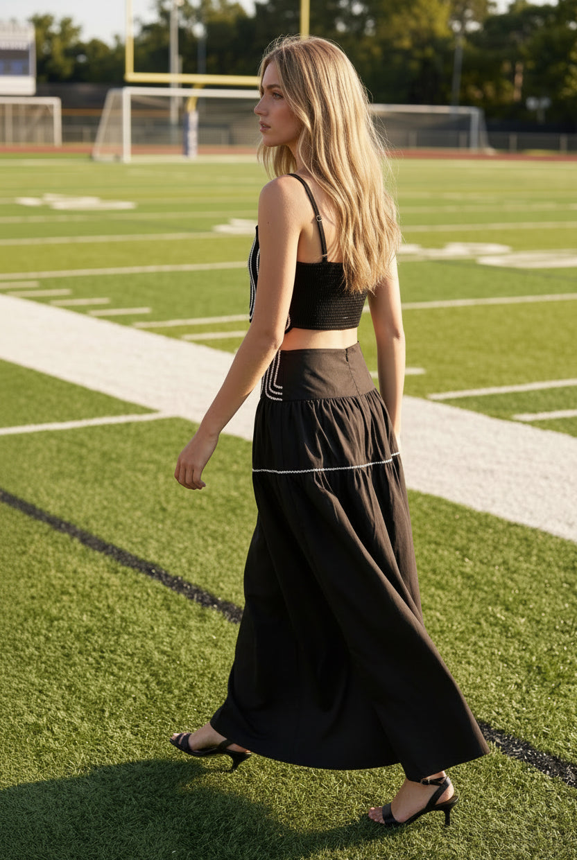 Women's black two-piece matching set with a fitted lace trim crop top and flowy maxi skirt. Fully lined lightweight fabric with a comfortable smocked back and elegant silhouette. Perfect boutique outfit for game day, tailgates, date nights, resort vacations, and summer events.