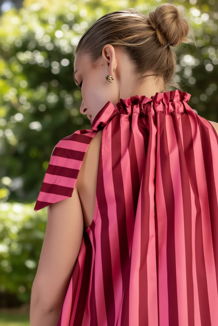 Close-up of a women's striped top showing the ruffled tie neckline and self-tie bow detail, creating a feminine and polished look for summer outfits.