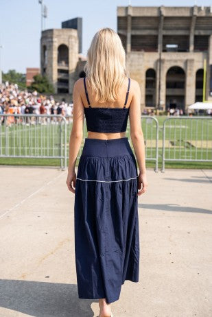 Full front view of a navy and white two-piece skirt set for women with a fitted top, delicate lace trim, and relaxed flowing skirt for a polished football game day look.