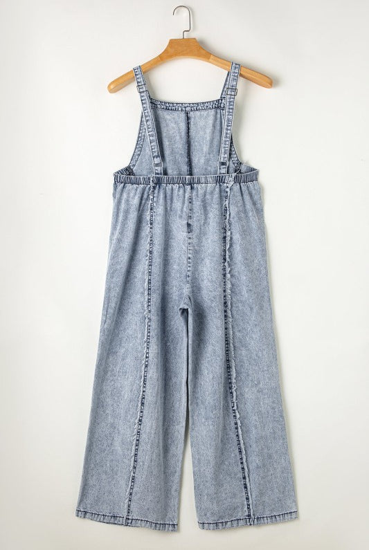 Casual chic wide leg overalls from Thread Bar Boutique in light wash denim with unique reverse seams and playful frayed detailing flat lay rear