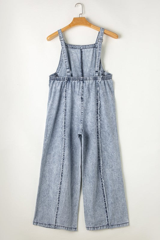 Casual chic wide leg overalls from Thread Bar Boutique in light wash denim with unique reverse seams and playful frayed detailing flat lay rear