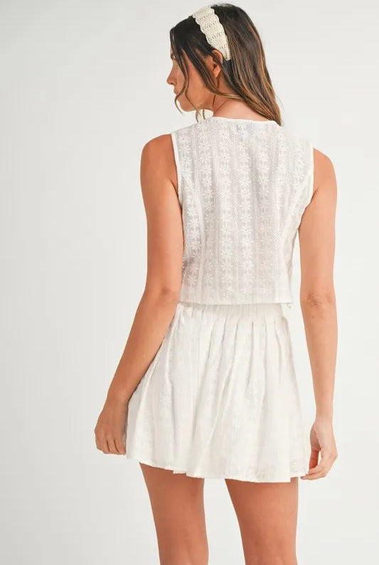 Two-piece set featuring an eyelet lace top and mini skirt, styled for a trendy and feminine look