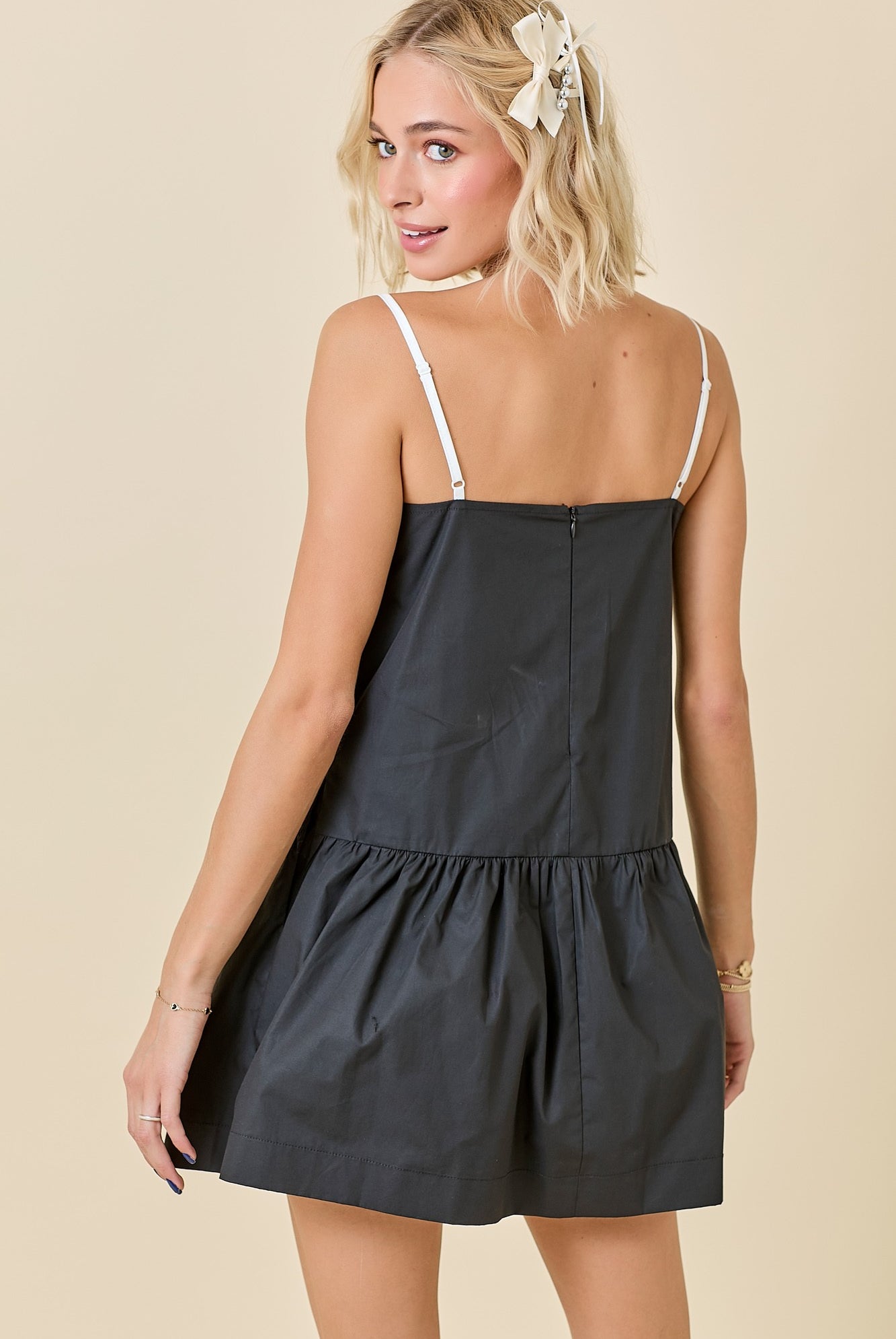 Black and white drop-waist mini dress featuring contrast knotted edge detailing, a sporty silhouette, and a relaxed fit — perfect for game day or casual chic styling.