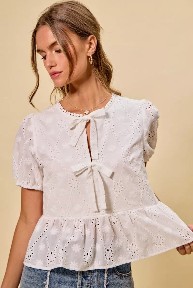 Cotton eyelet blouse from Thread Bar Boutique featuring delicate embroidery and front tie detail for a romantic summer outfit.