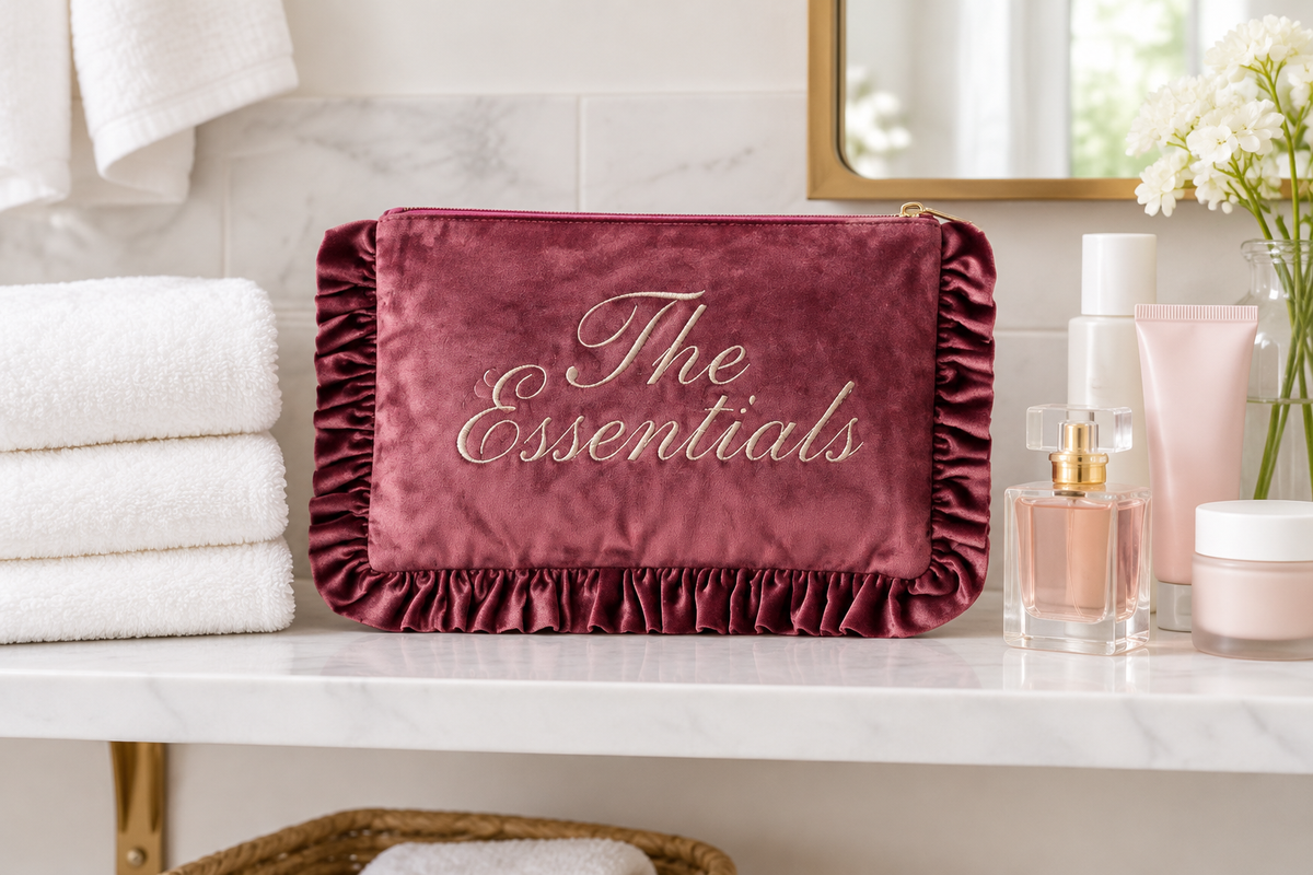 The Essentials velvet ruffle makeup bag styled on a bathroom shelf