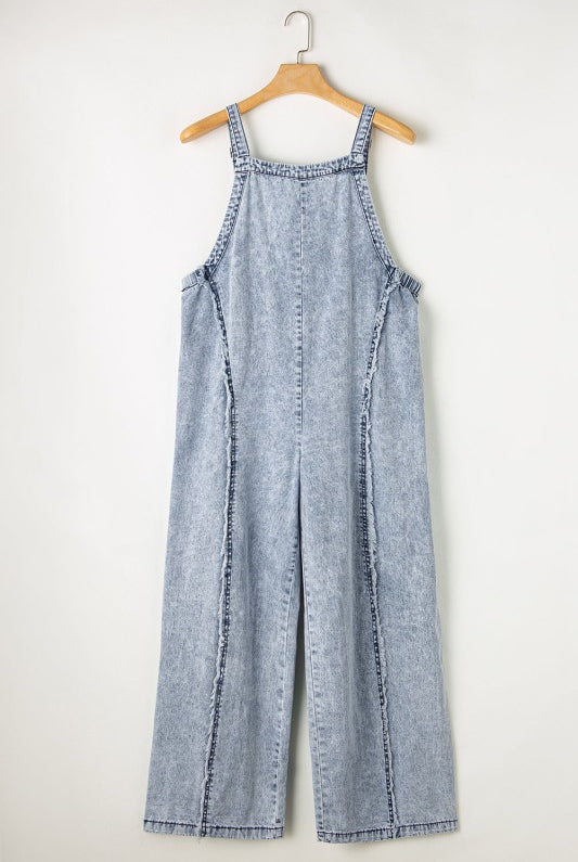 Casual chic wide leg overalls from Thread Bar Boutique in light wash denim with unique reverse seams and playful frayed detailing flat lay