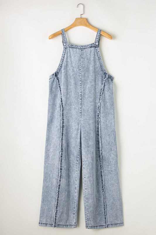 Casual chic wide leg overalls from Thread Bar Boutique in light wash denim with unique reverse seams and playful frayed detailing flat lay