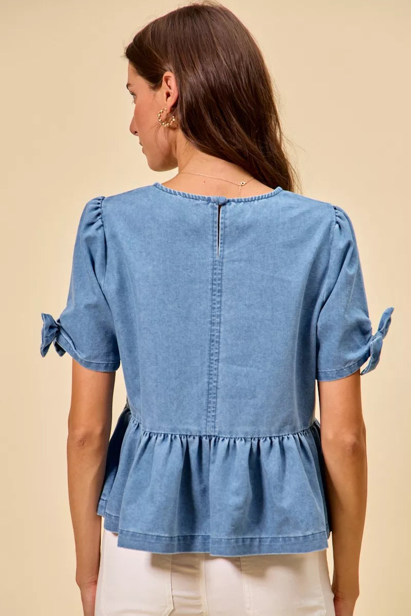 Women’s soft denim peplum blouse with bow neckline at Thread Bar Boutique