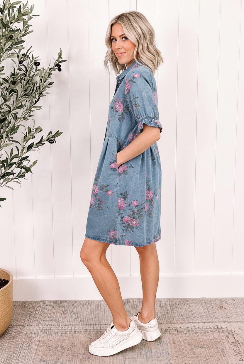 Sky blue floral denim shirt dress 3/4 back view showing ruffled cuff sleeves, A-line shift silhouette, and all-over pink rose print on enzyme-washed denim