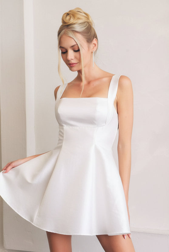 White fit and flare skater dress with gathered bust and dramatic back cutout