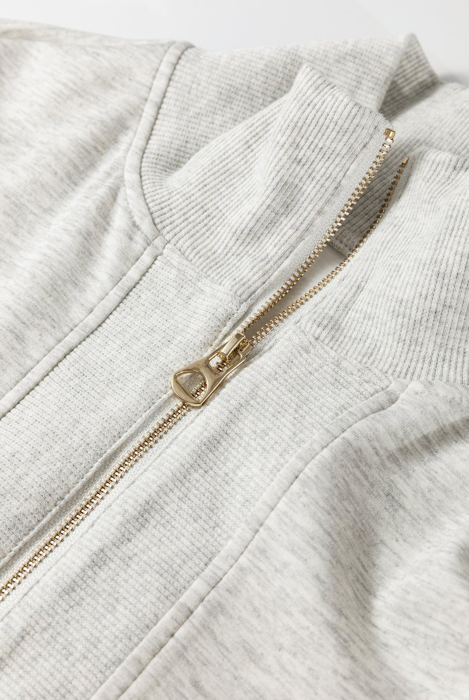 Detail shot of zipper collar and fabric texture on light grey two piece set