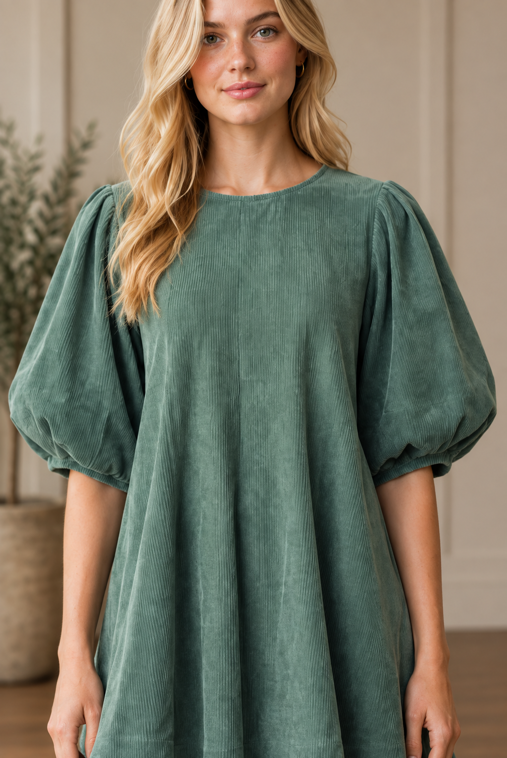 Half body detail shot of the bubble sleeves, round neck, and corduroy texture