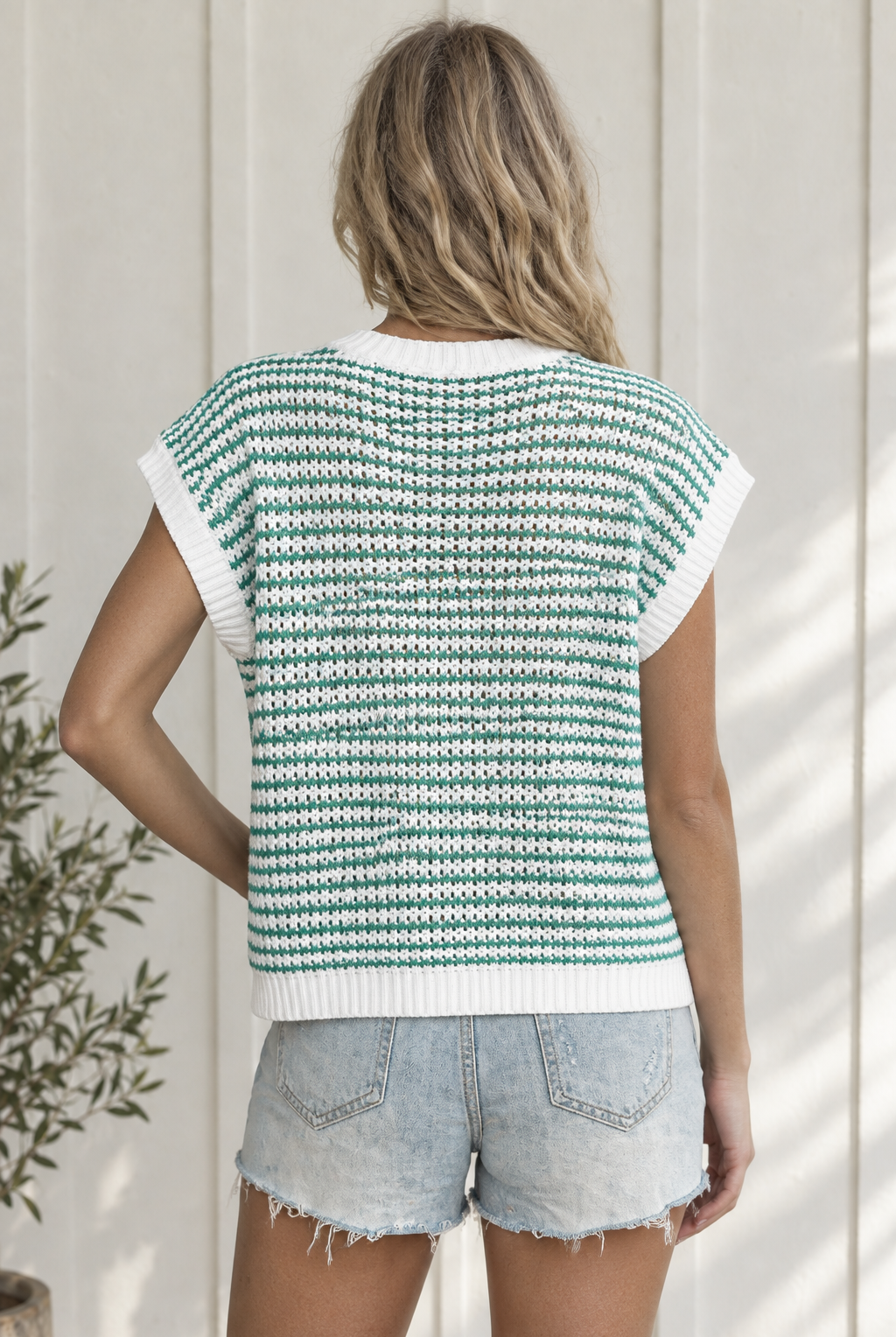 Back view of green striped sleeveless knit tank showing textured knit, relaxed shape and white ribbed hem