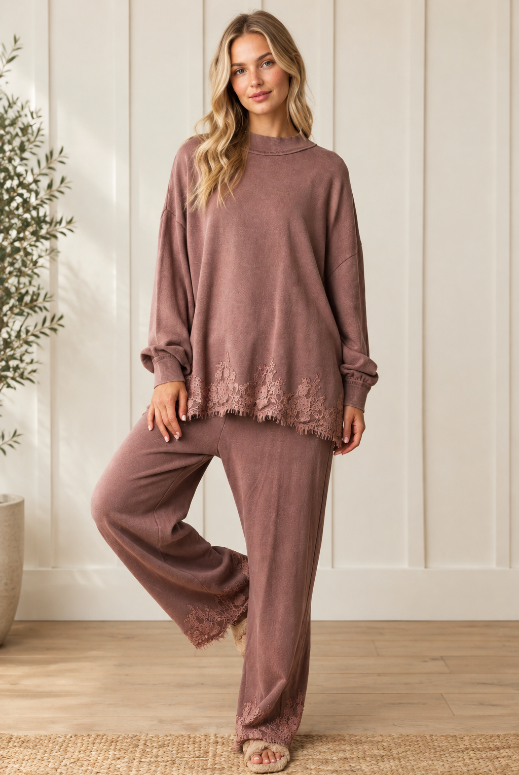 Front view of mauve-brown lace hem French terry track pants, showing the relaxed wide-leg fit with one knee bent.