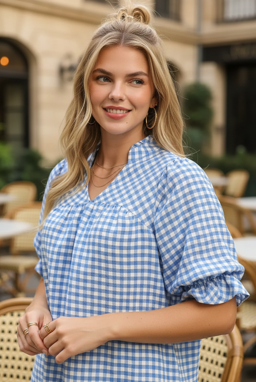 Blue white gingham ruffle sleeve blouse waist-up close-up — V-neck gathered yoke and ruffle elbow sleeve detail blonde model golden light