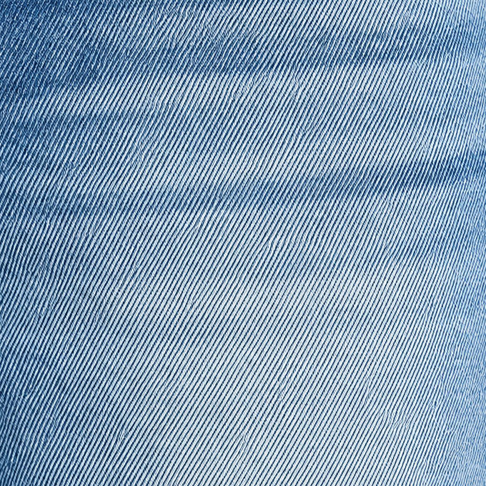 Close-up of medium wash denim showing fabric weave, faded finish and front pocket stitching on barrel jeans