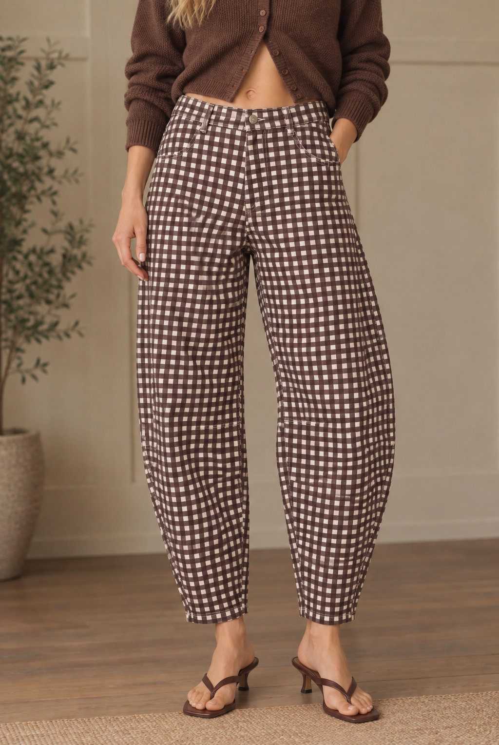 Brown gingham barrel pants showing button closure, belt loops, front pockets and rounded legs tapering at the ankles.