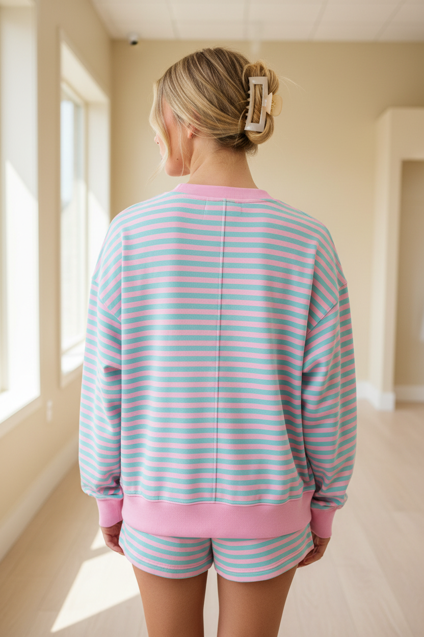 Back view of blonde model in pink and mint teal stripe oversized pullover sweatshirt and shorts set with pink ribbed trim, Thread Bar Boutique