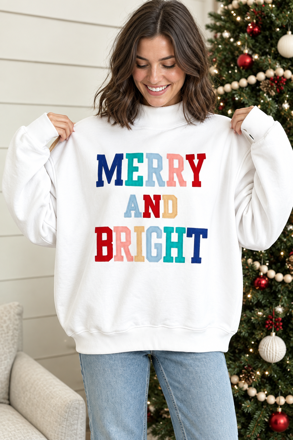 White Merry and Bright pullover showing relaxed shape, mock neckline and multicolor stitched holiday lettering
