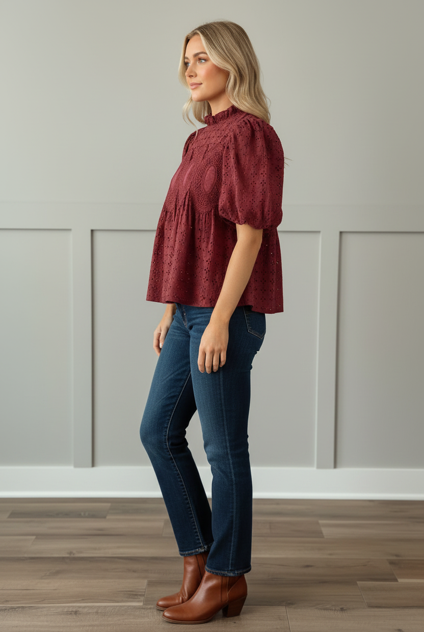 Side profile view of cranberry 100% cotton eyelet puff sleeve blouse showing voluminous short puff sleeves and relaxed babydoll fit