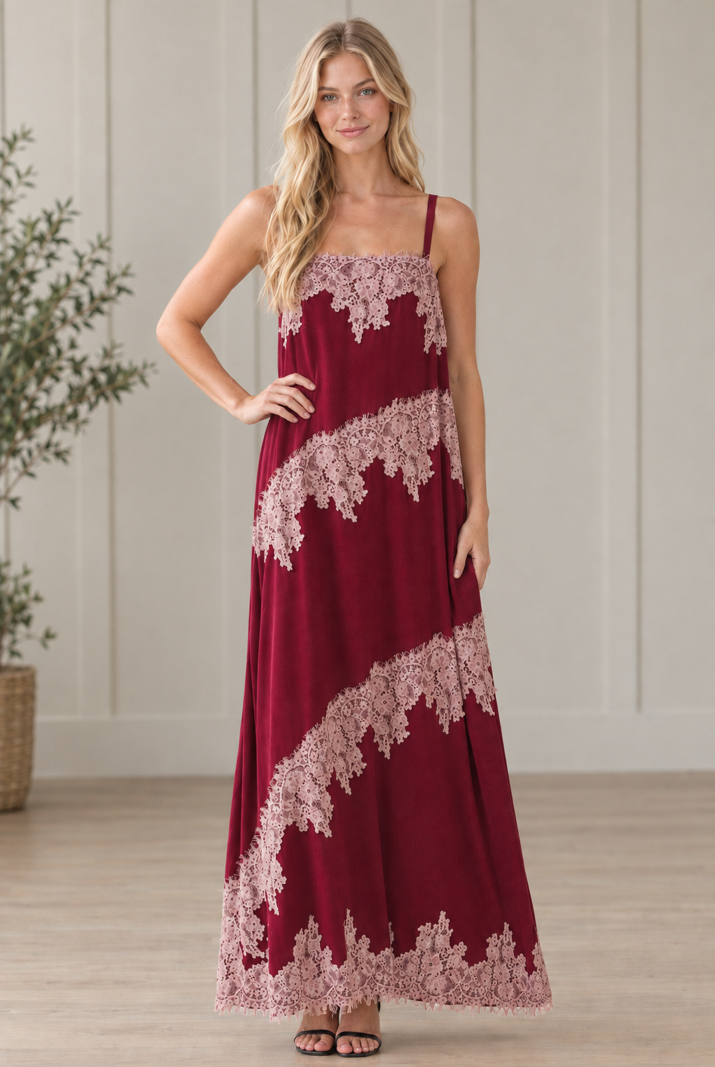 Blonde model with hand on hip wearing burgundy contrast floral lace maxi dress with square neckline and spaghetti straps