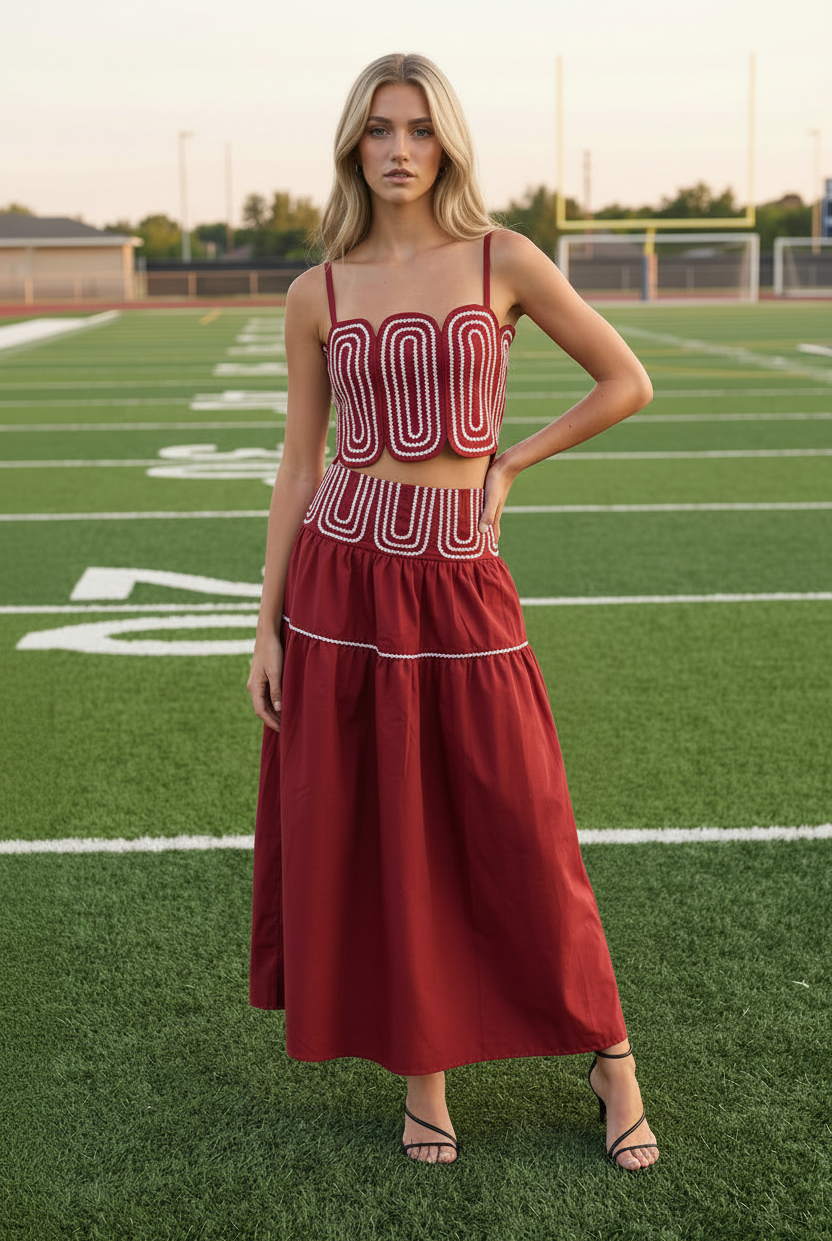 Blonde model wearing crimson red lace trim crop top and tiered maxi skirt set - front facing on football field