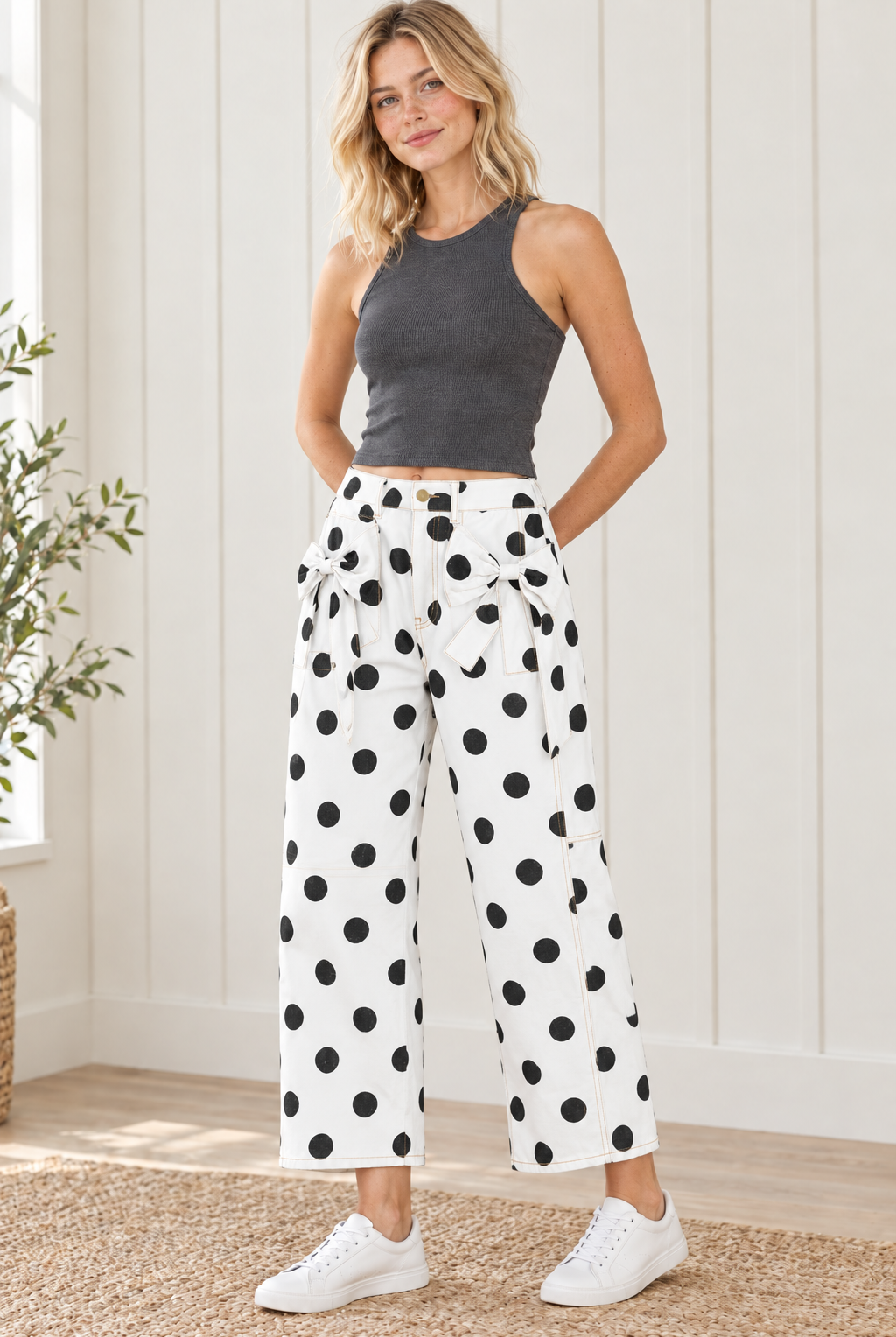 Front view of white polka dot bow detail jeans with black dots, front patch pockets, belt loops and side panel seams