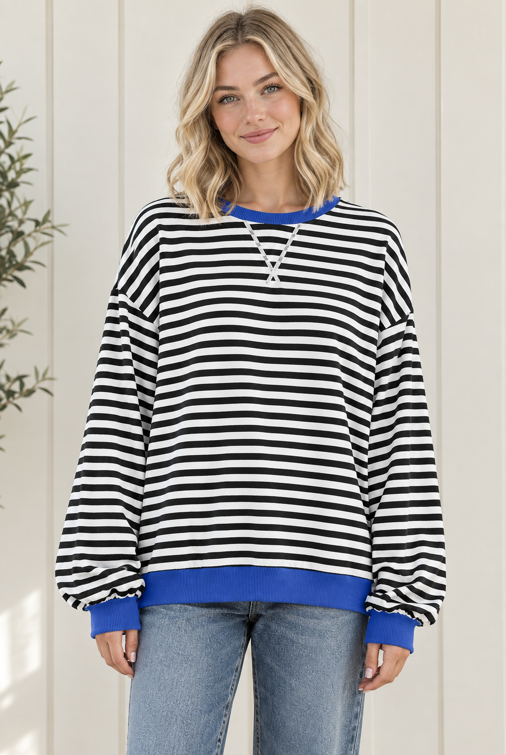 Front view of women's oversized black and white striped sweatshirt with blue trim and drop shoulders.