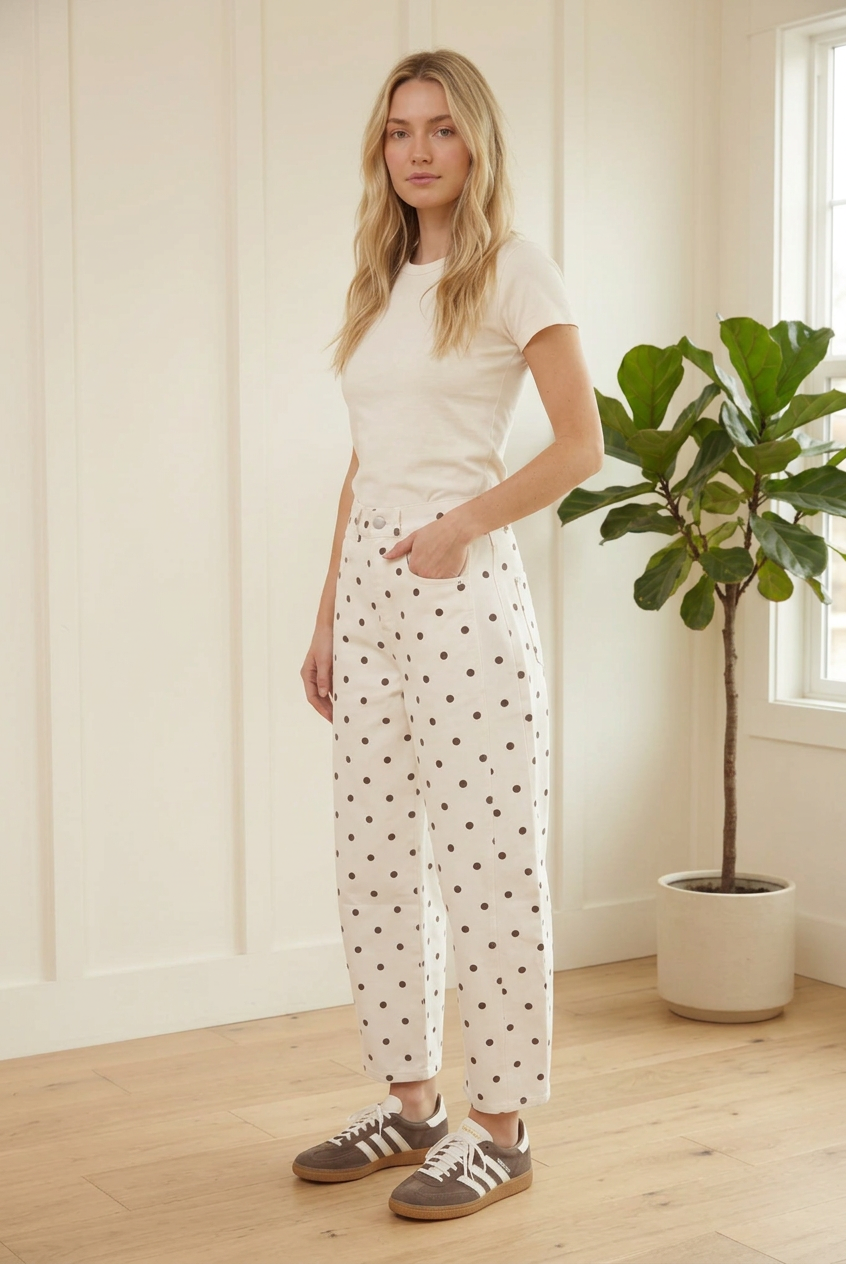 Angled view of ecru polka dot barrel jeans showing the high waist, front pockets and relaxed curved legs.
