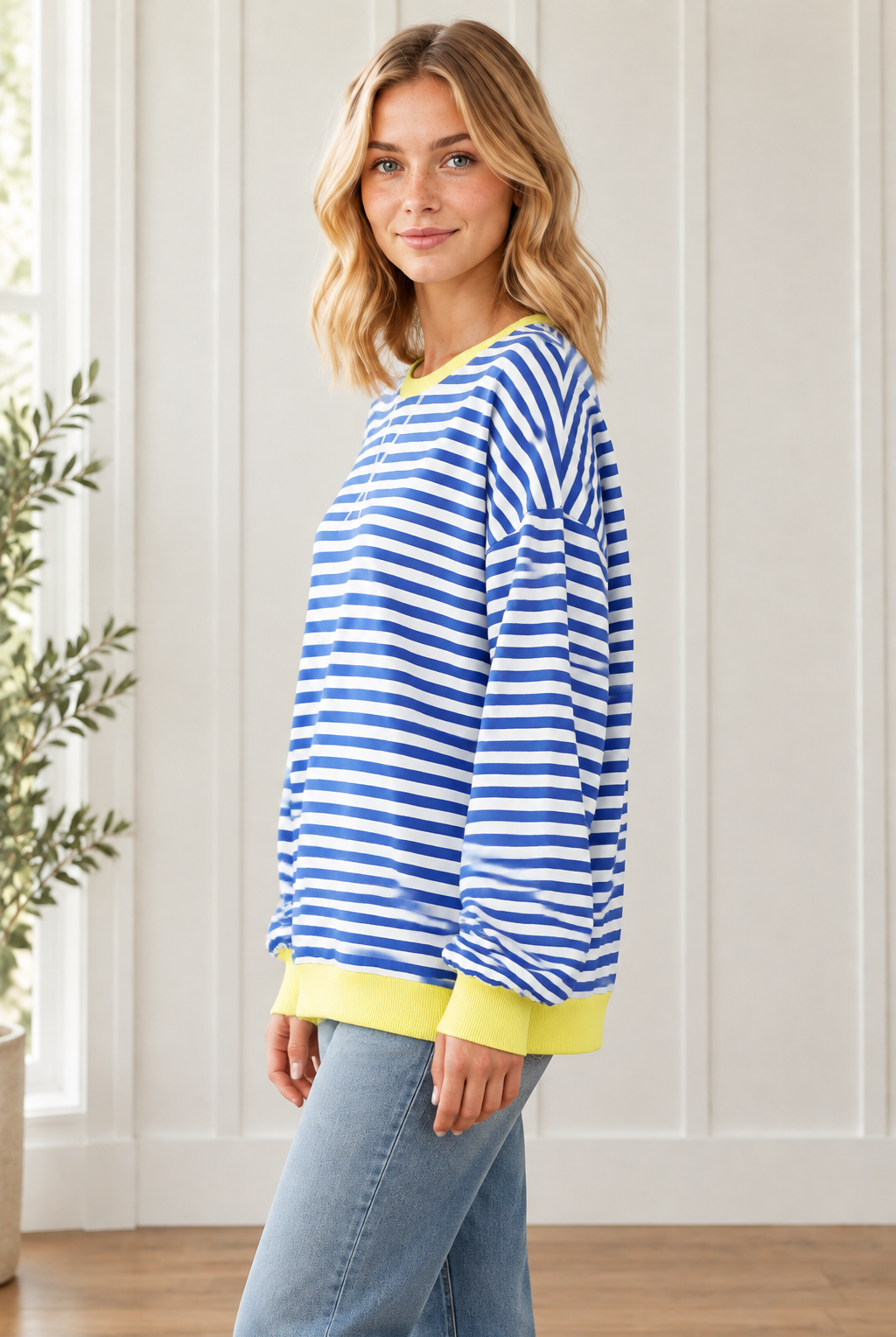 Side view of relaxed Blue Stripe pullover showing dropped shoulders, loose sleeves and yellow contrast trim.