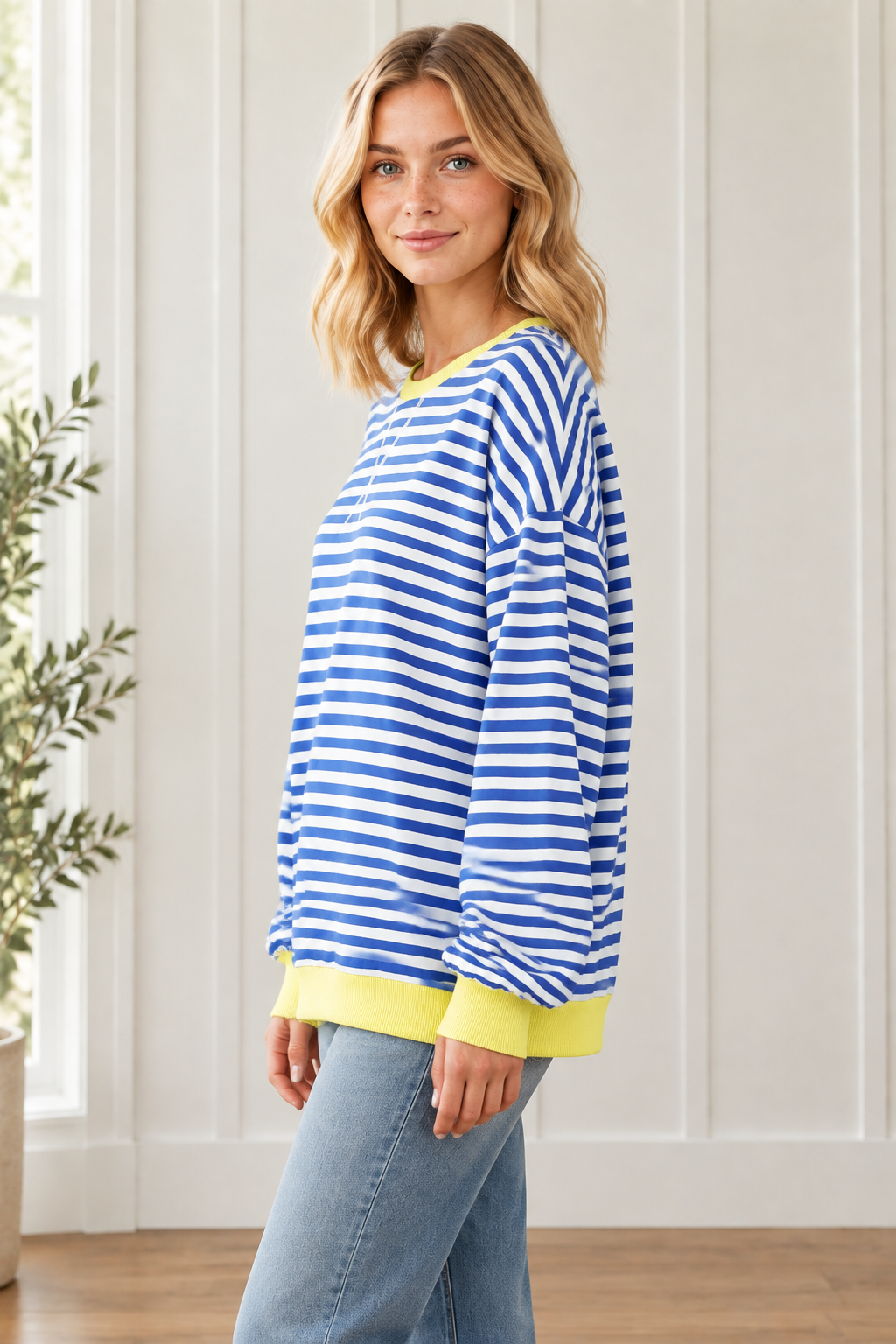 Side view of relaxed Blue Stripe pullover showing dropped shoulders, loose sleeves and yellow contrast trim.