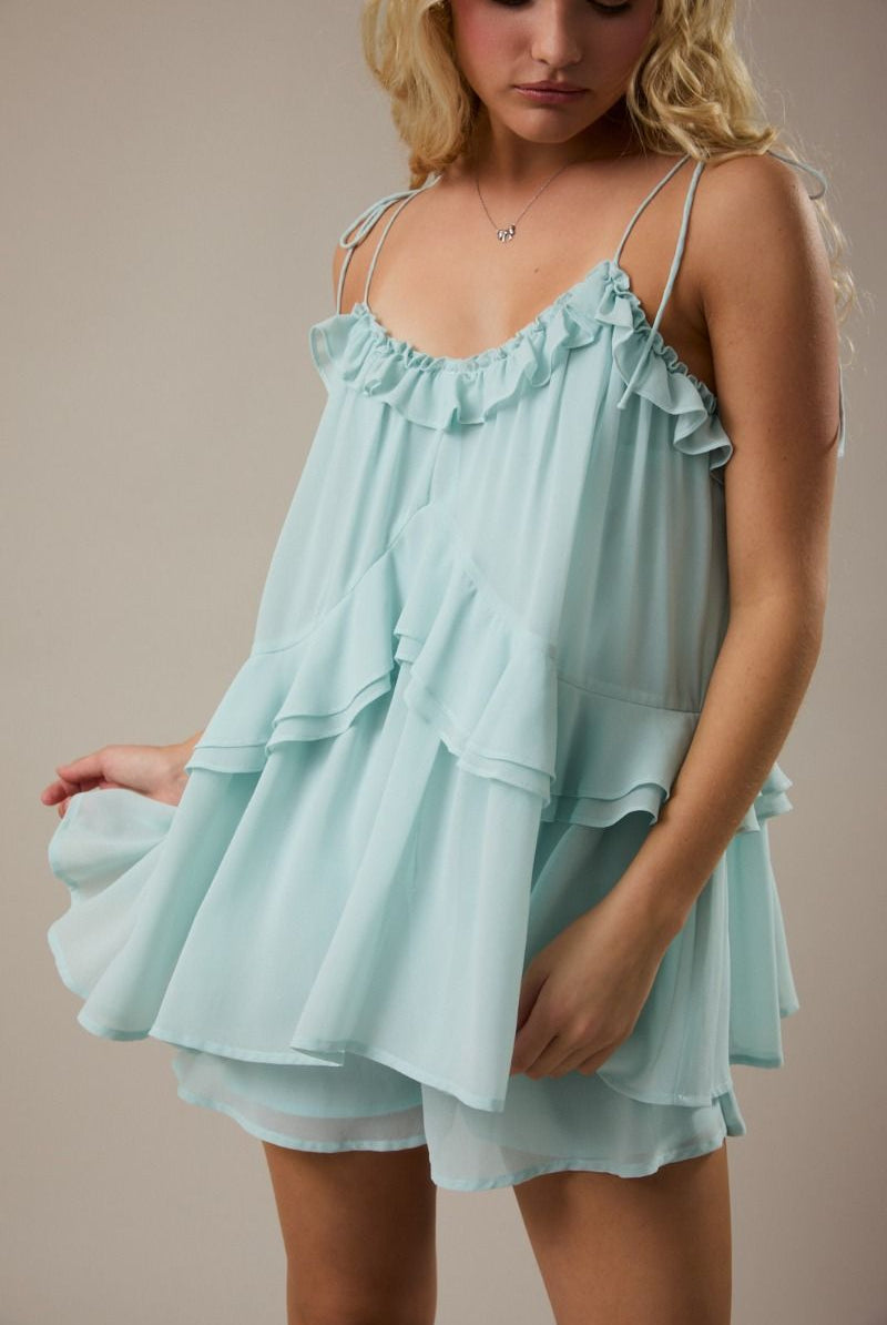 Women's mint green ruffle romper with tie shoulders and breezy flared legs from Thread Bar Boutique, a stylish lightweight summer boutique romper.