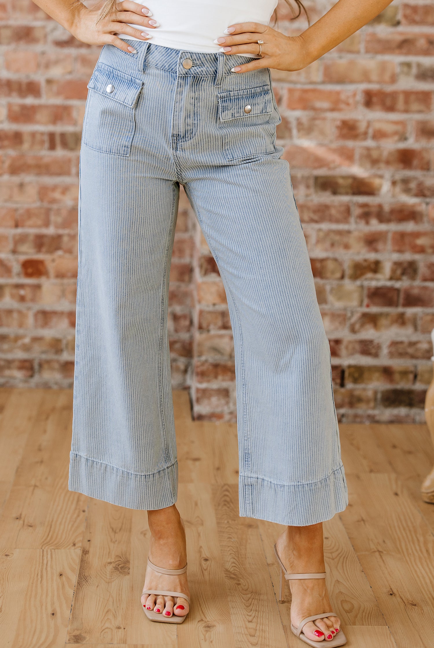 Light wash pinstripe denim jeans with relaxed wide leg fit and rolled cuffs