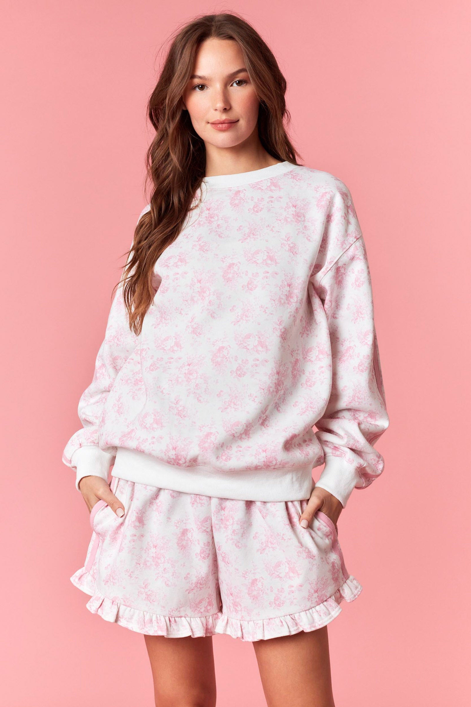 Soft white sweatshirt with pink floral print for women from Thread Bar Boutique
White thigh-length drawstring shorts with pink floral print for women from Thread Bar Boutique