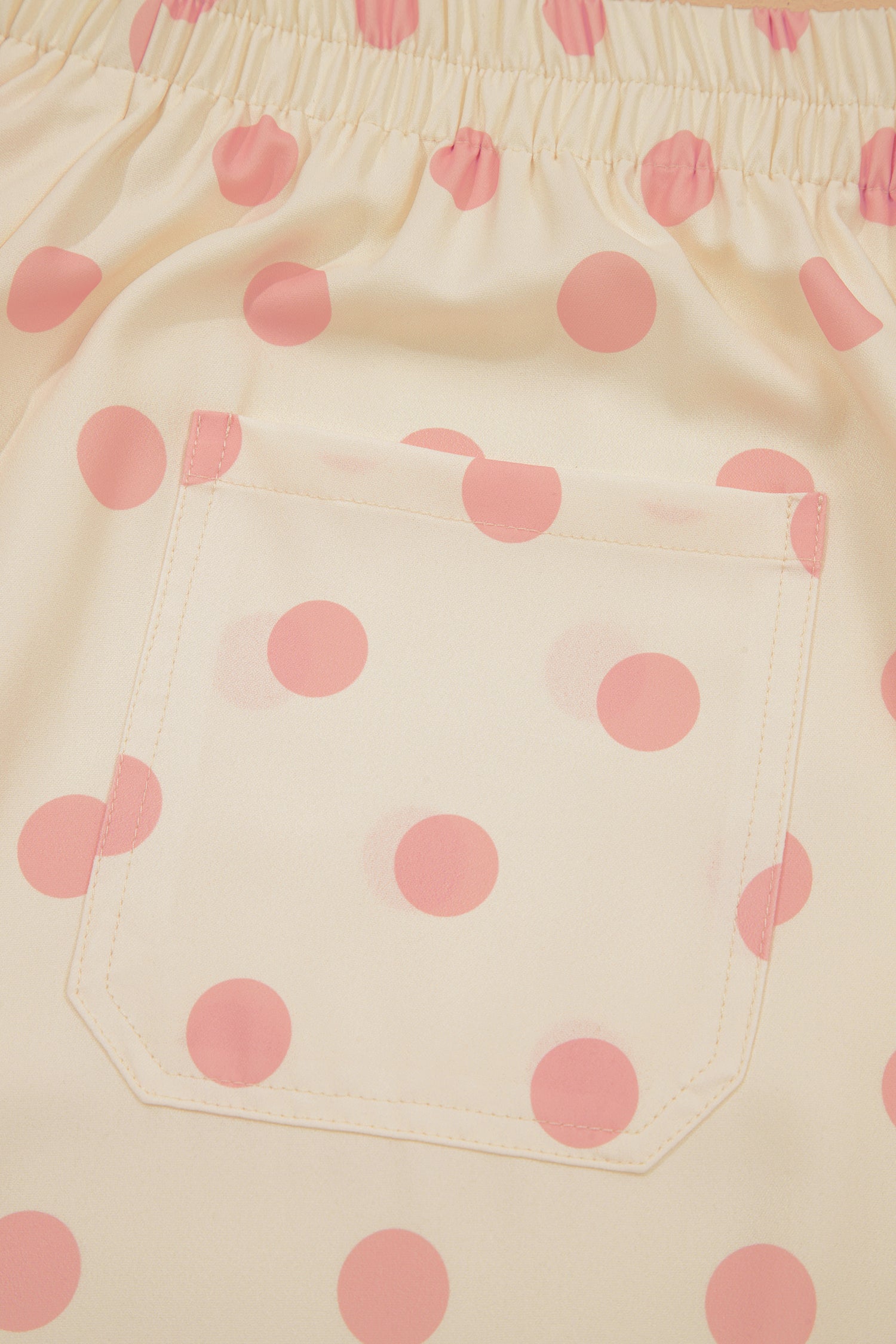 Close-up of pink polka dot fabric on a beige background